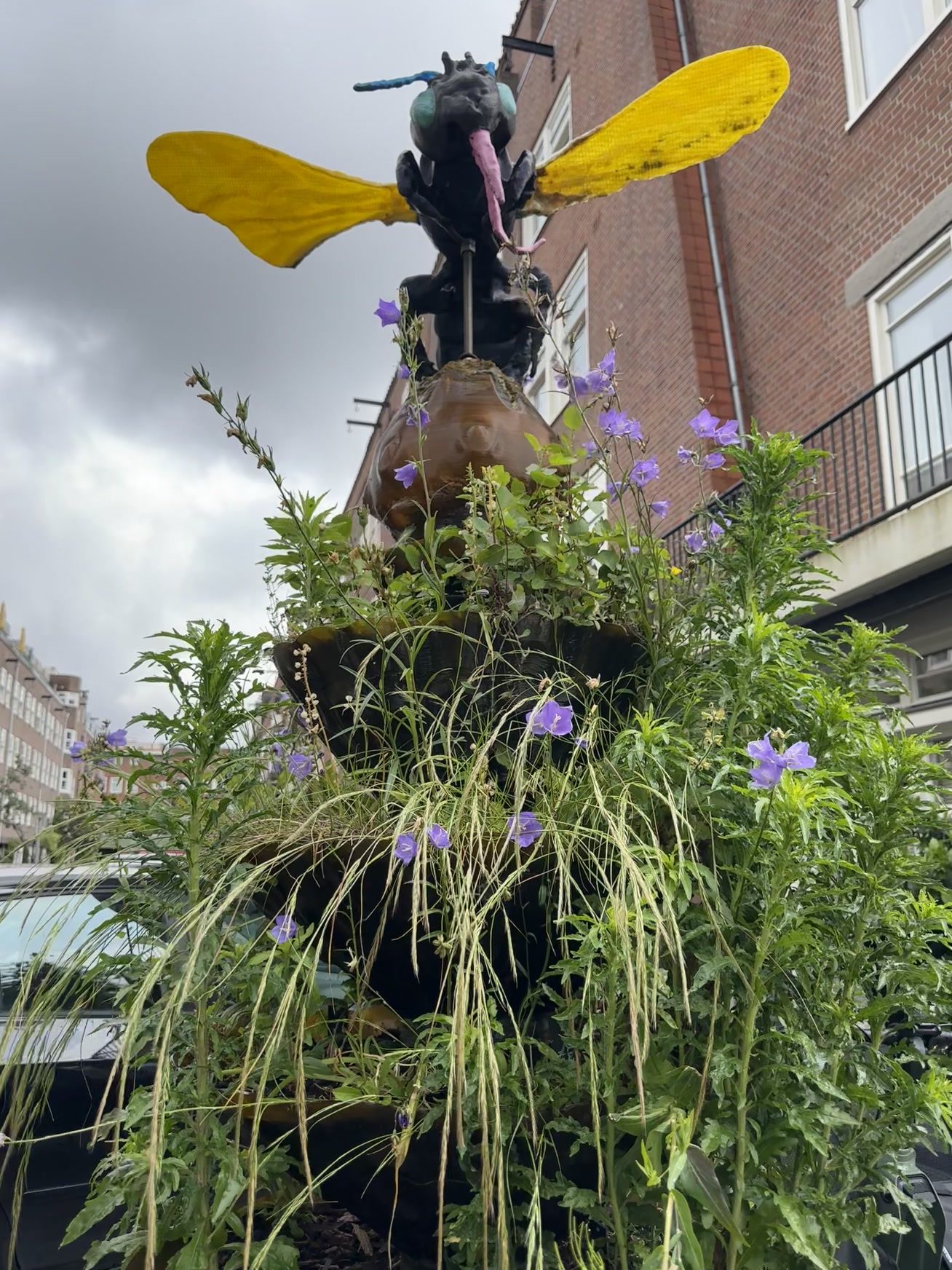 Totem met gele vleugels in een Amsterdamse straat